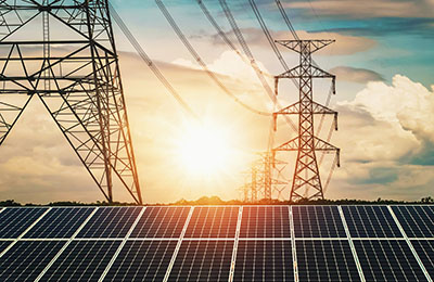 Solar panels with electricity pylon and sunset. Clean power ener