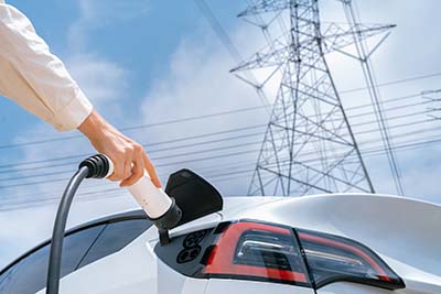 Closeup woman recharge EV electric car battery at charging station. Expedient